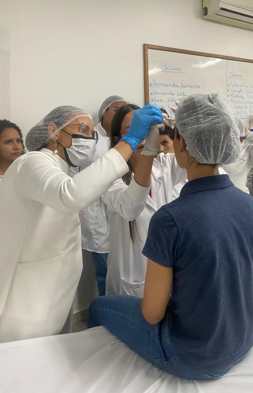 Dra. Viviane orientando alunos em aula prática de estética avançada